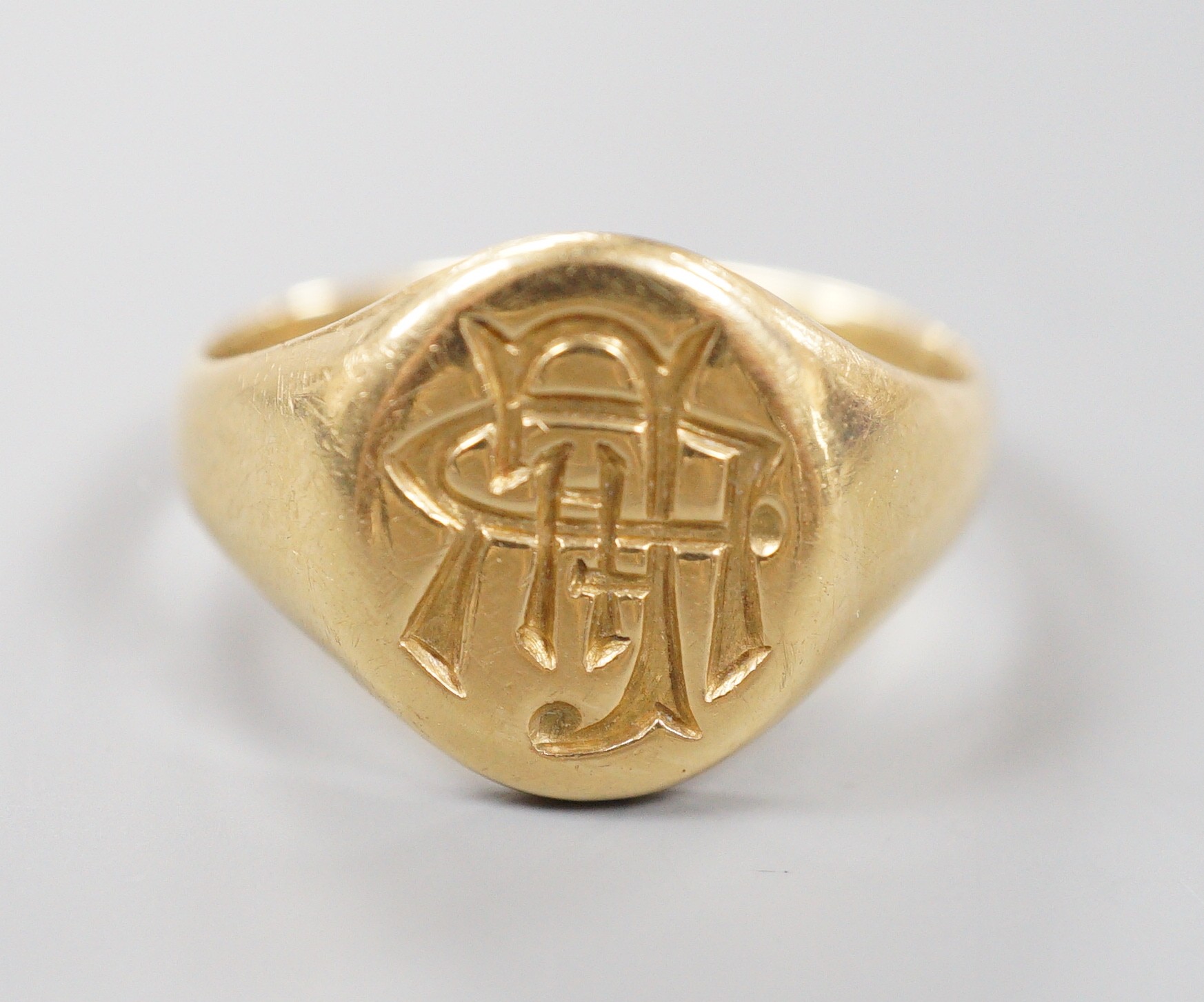 A George V 18ct gold oval signet ring, with intaglio monogram and engraved inscription, size S/T, 8.1 grams.